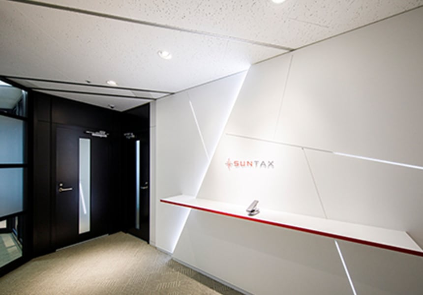 白を基調としたオフィスエントランス、壁面にSUNTAXのロゴが見える
